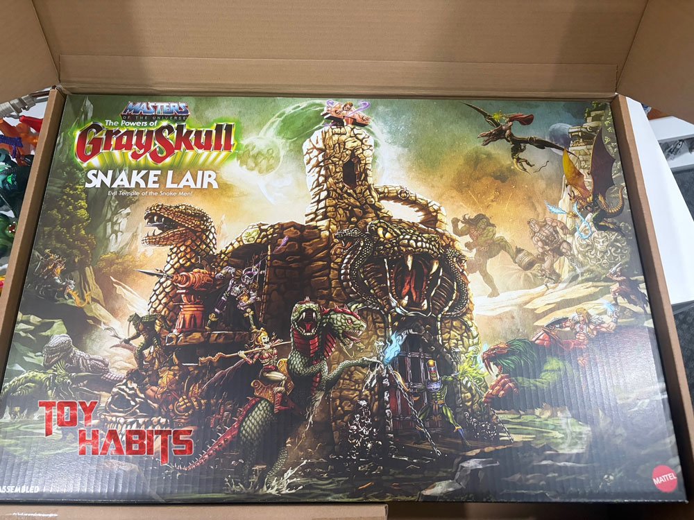 Here's a closer look at the Snake Lair box as it arrives inside its protective brown shipper, and the artwork truly pops with those warm golds and burnt oranges once you see it in person. The sheer size of this box is immediately impressive, filling the shipper almost completely, and you get a real sense of the playset's ambition just from how much the illustration crams into a single scene.