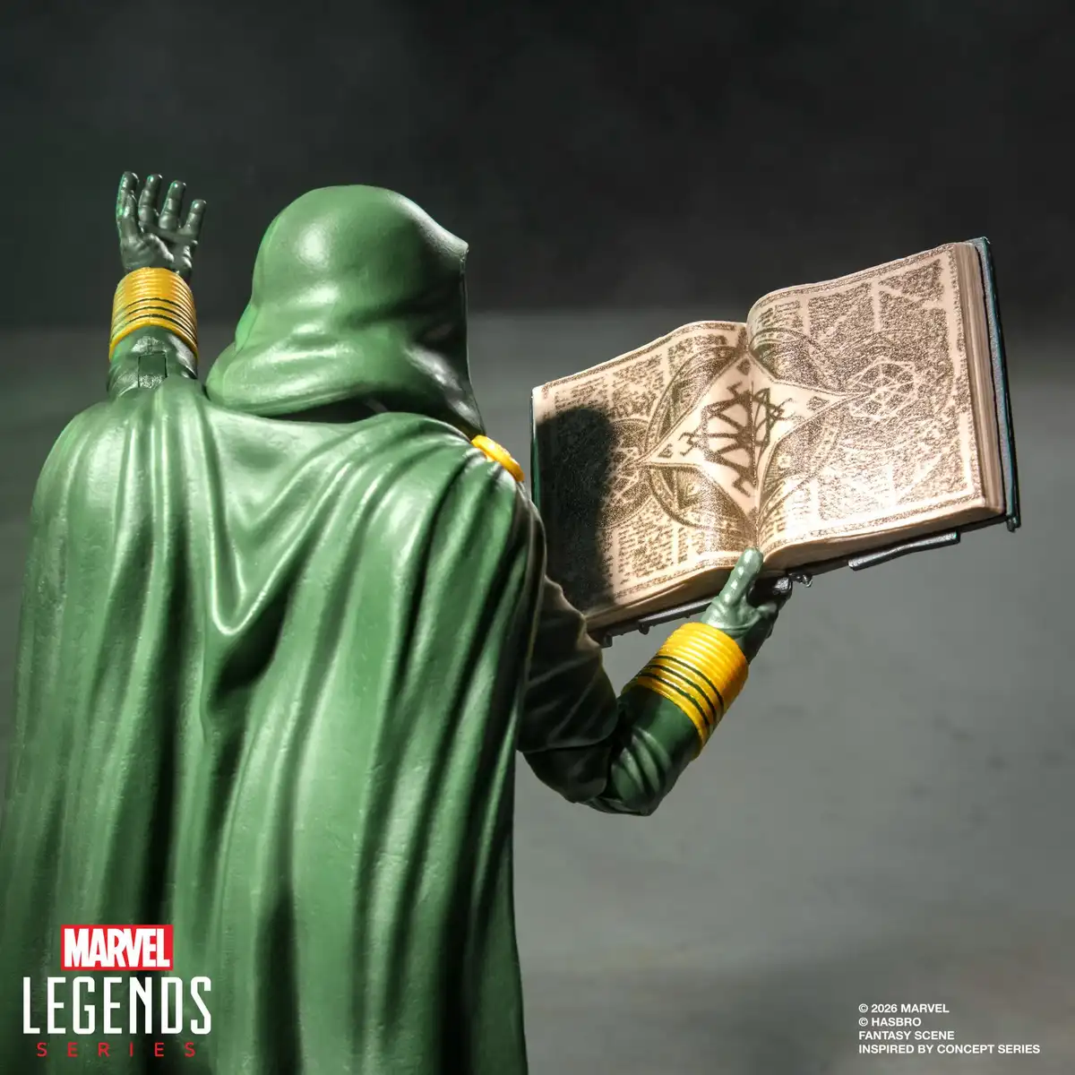 Rear three-quarter view of Lord Doom holding an open book featuring printed mystical illustrations.