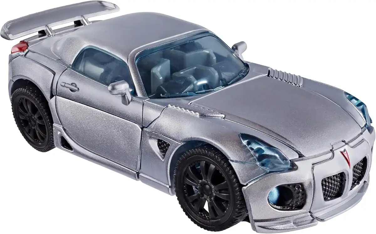 Jazz transforms into a silver sports car with dark wheels, a blue-tinted windshield, and sculpted vents along the hood and sides.