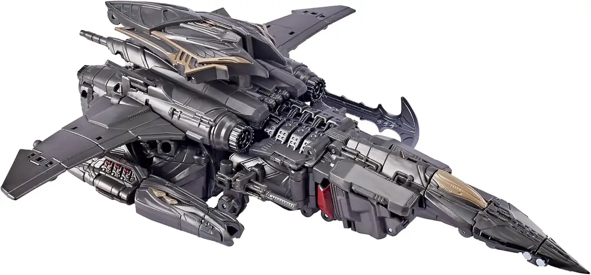 Megatron’s Cybertronian jet mode has swept wings, a long pointed nose, twin rear engines, and layered dark metallic panels with bronze accents.