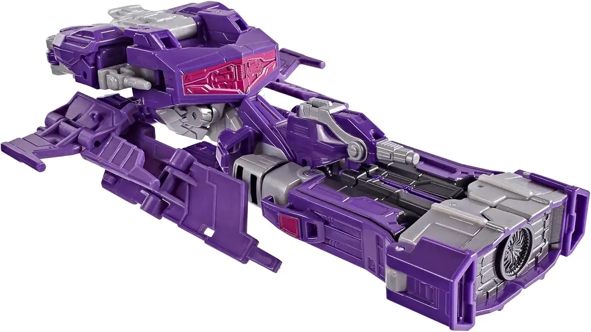 Shockwave’s purple Cybertronian vehicle mode has a broad, low body, gray mechanical details, a magenta front panel, and a large circular rear component.
